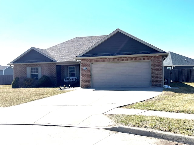 ranch-style home with concrete driveway, an attached garage, fence, a front lawn, and brick siding