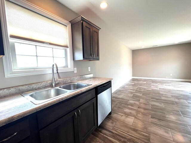 kitchen with dark brown cabinetry, a sink, baseboards, light countertops, and stainless steel dishwasher