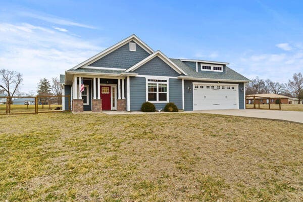 craftsman-style house with a garage, concrete driveway, and a front lawn