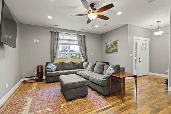 living area with recessed lighting, baseboards, wood finished floors, and a ceiling fan