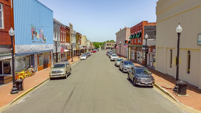 view of road featuring sidewalks, curbs, and street lighting