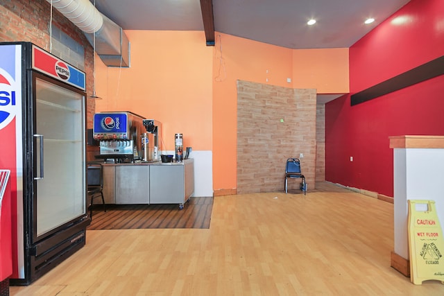 kitchen featuring fridge, lofted ceiling with beams, wood finished floors, and recessed lighting