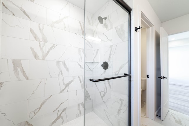 full bath with a marble finish shower, marble finish floor, and toilet