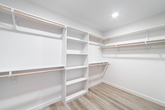 walk in closet with wood finished floors