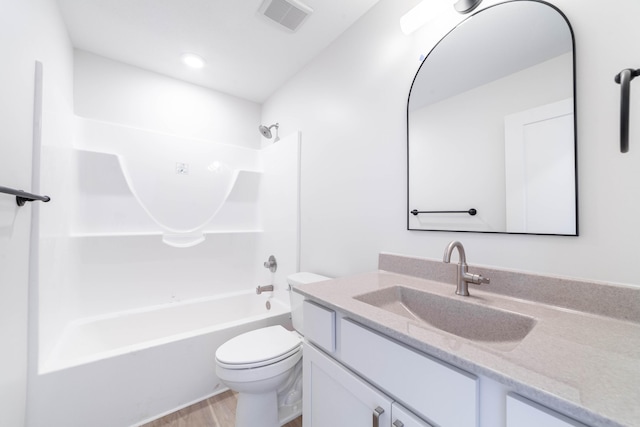 bathroom featuring visible vents, toilet, wood finished floors, vanity, and shower / bathtub combination