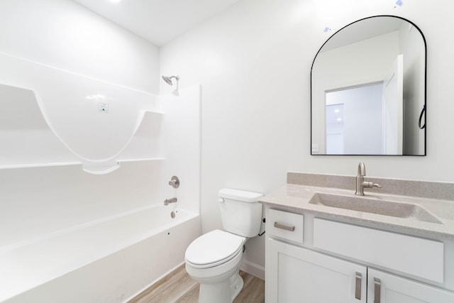 bathroom with toilet, wood finished floors, baseboards, bathtub / shower combination, and vanity