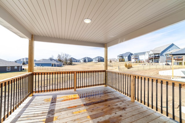 wooden terrace featuring a fenced backyard and a residential view