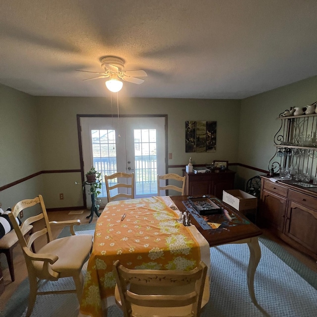 bedroom featuring ceiling fan, access to outside, french doors, and a textured ceiling