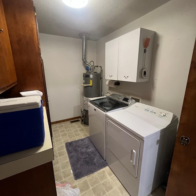 washroom featuring gas water heater, light floors, cabinet space, a textured ceiling, and separate washer and dryer