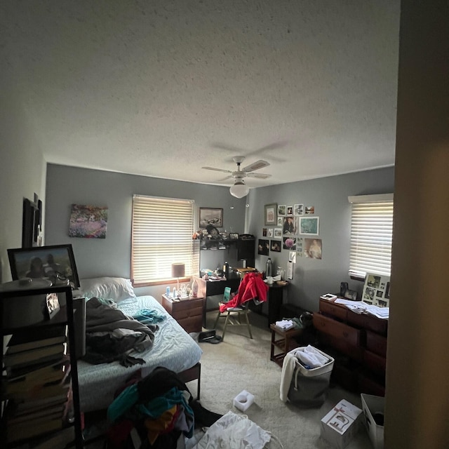 bedroom with carpet flooring, a textured ceiling, and ceiling fan