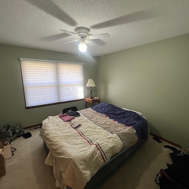 bedroom featuring baseboards, carpet, ceiling fan, and a textured ceiling