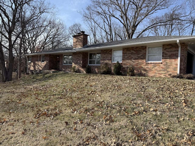 view of front of property featuring brick siding and a chimney