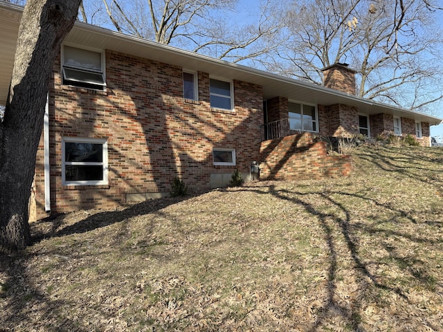 view of home's exterior with brick siding and a chimney