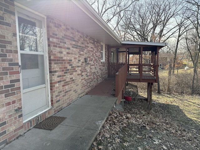 exterior space with a deck and brick siding