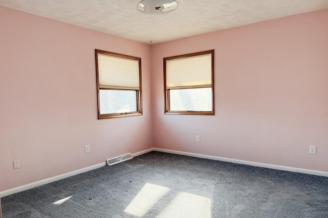 spare room featuring visible vents, baseboards, and carpet