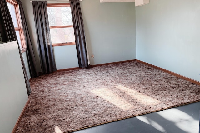 carpeted spare room with baseboards