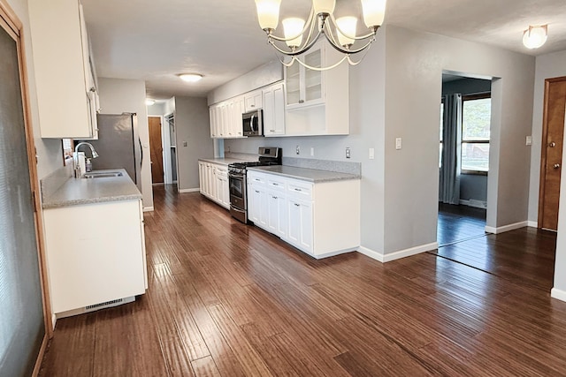 kitchen featuring a sink, appliances with stainless steel finishes, dark wood-style floors, and light countertops