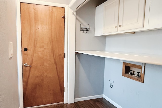 clothes washing area with baseboards, cabinet space, washer hookup, and dark wood finished floors