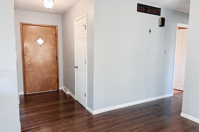 hallway with visible vents, baseboards, and wood finished floors