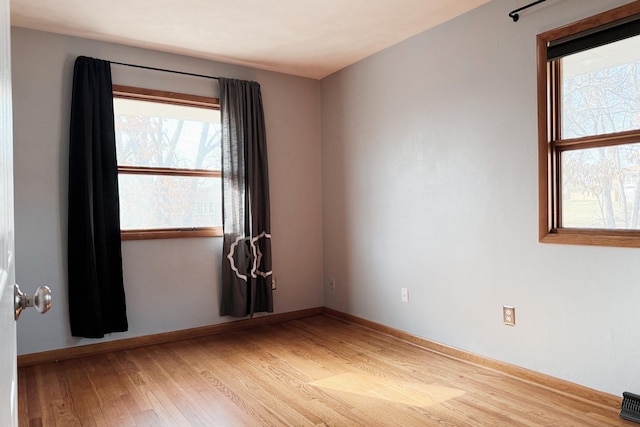 empty room with visible vents, baseboards, and light wood finished floors