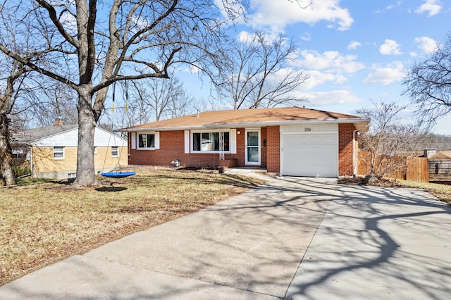 single story home featuring brick siding, concrete driveway, a garage, and fence