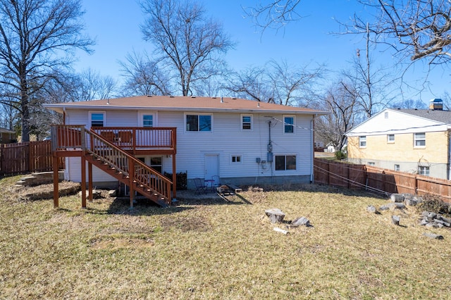 back of house featuring an outdoor fire pit, a yard, a fenced backyard, stairs, and a deck