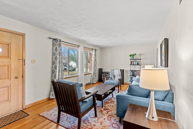 living area with light wood-type flooring and baseboards