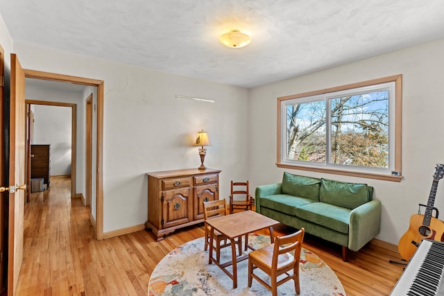 living area with light wood-style floors and baseboards