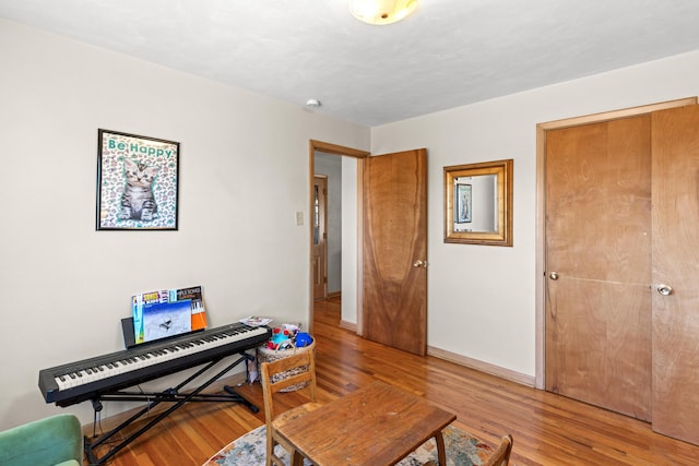 living area featuring baseboards and light wood-style flooring