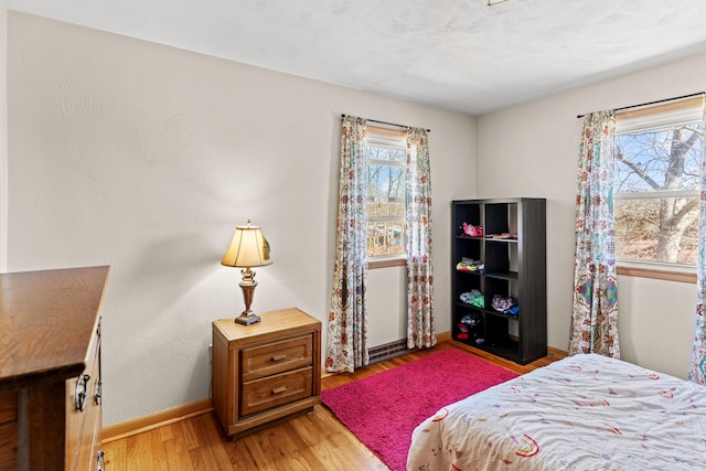 bedroom featuring light wood-style floors and baseboards