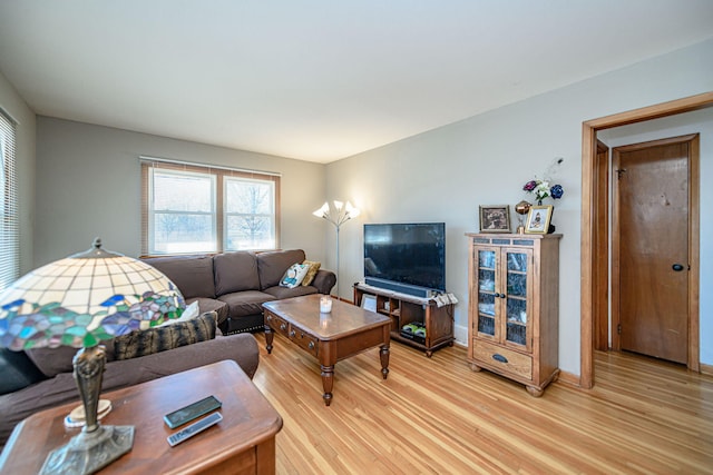 living area featuring baseboards and light wood finished floors