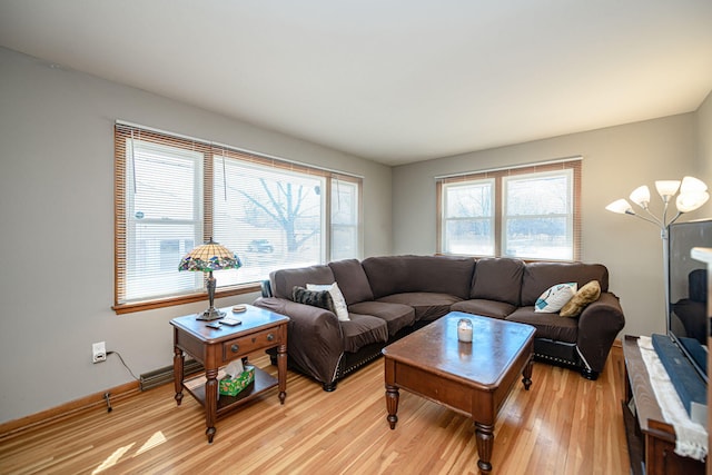 living area with light wood-type flooring and baseboards