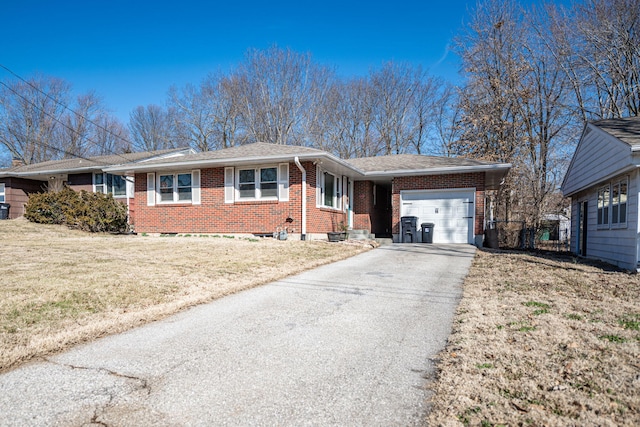 view of front of home featuring brick siding, an attached garage, driveway, and a front lawn