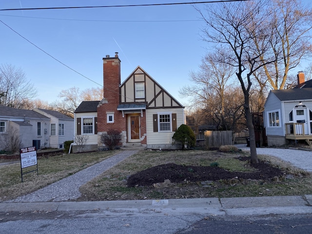 view of front of house featuring central air condition unit, fence, and a chimney