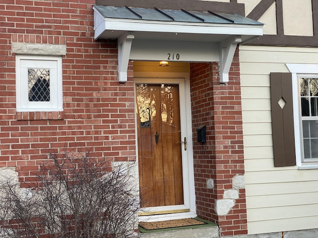 doorway to property with brick siding