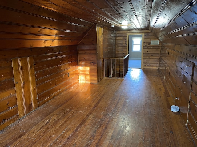 additional living space featuring visible vents, hardwood / wood-style floors, wooden walls, lofted ceiling, and wood ceiling