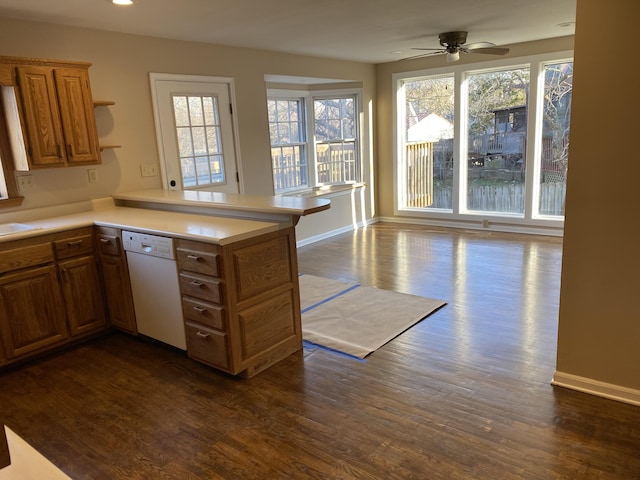 kitchen with dark wood-style floors, a peninsula, light countertops, and white dishwasher