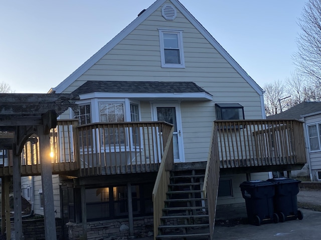 rear view of property featuring stairway, a shingled roof, and a deck