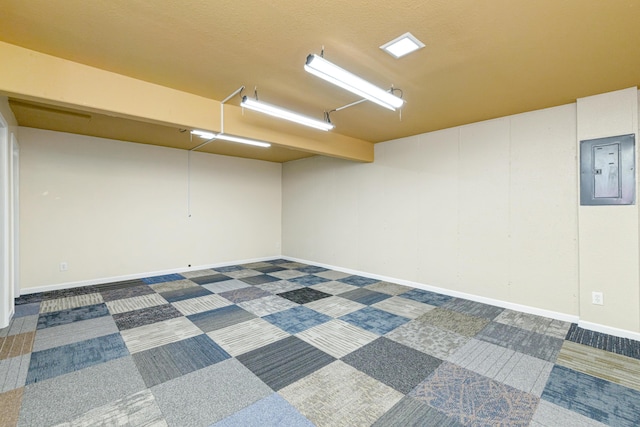 empty room featuring electric panel, baseboards, and carpet