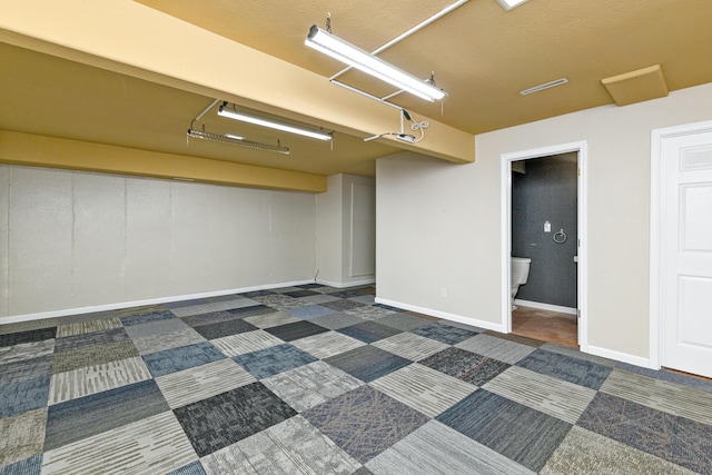 finished basement featuring dark carpet and baseboards