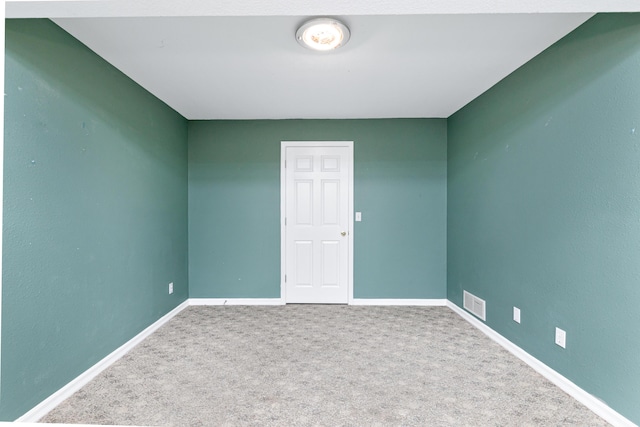 spare room with visible vents, baseboards, and carpet