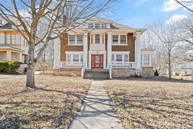 greek revival inspired property with covered porch and brick siding