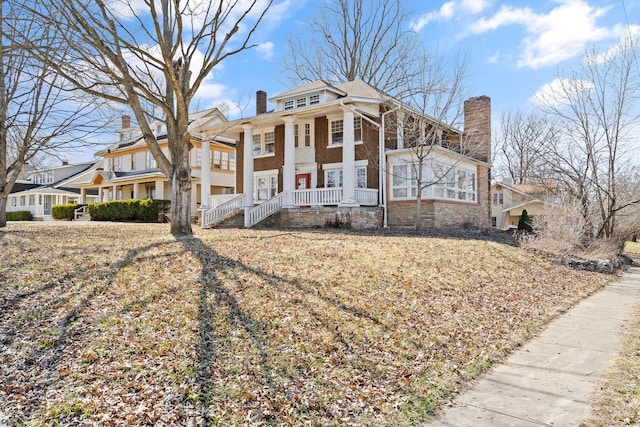 neoclassical home with brick siding, covered porch, and a chimney