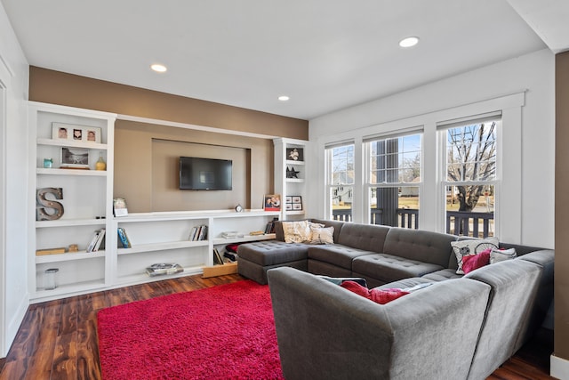 living area with dark wood finished floors, recessed lighting, and built in shelves