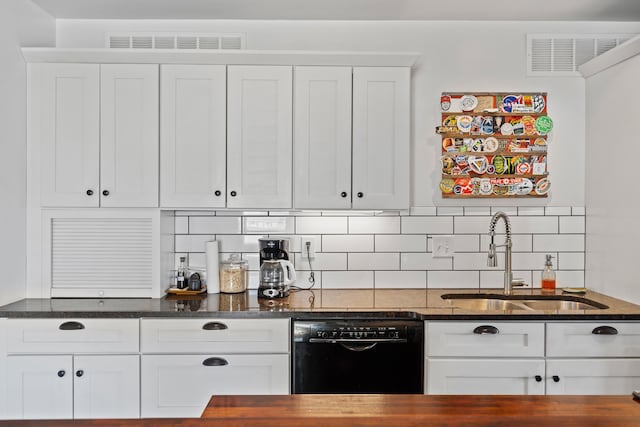 kitchen with a sink, visible vents, black dishwasher, and dark stone counters