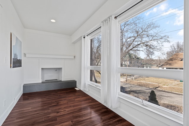 sunroom / solarium featuring a fireplace with raised hearth