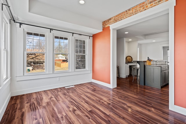 spare room with dark wood finished floors, visible vents, recessed lighting, and baseboards