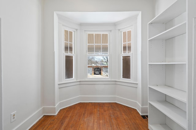 interior space with baseboards and dark wood-style flooring