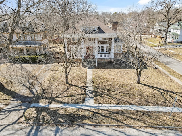 view of front of house featuring a porch and a chimney