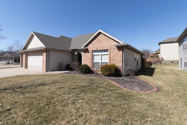 ranch-style home with a shingled roof, concrete driveway, a front yard, an attached garage, and brick siding